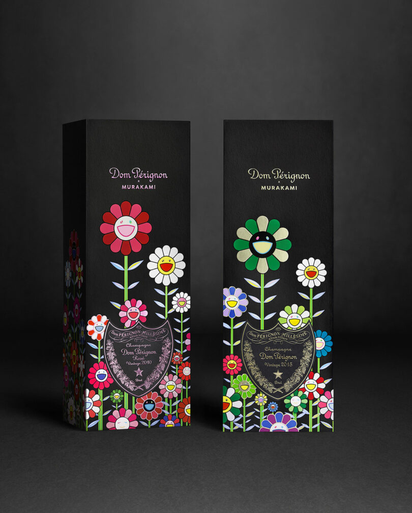 Two black Takashi Murakami Dom Perignon boxes feature colorful, stylized flower designs and the label for a 2014 vintage champagne against a dark background.