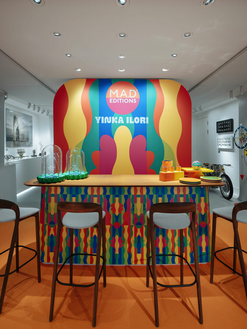 A colorful wall with a bar and chairs